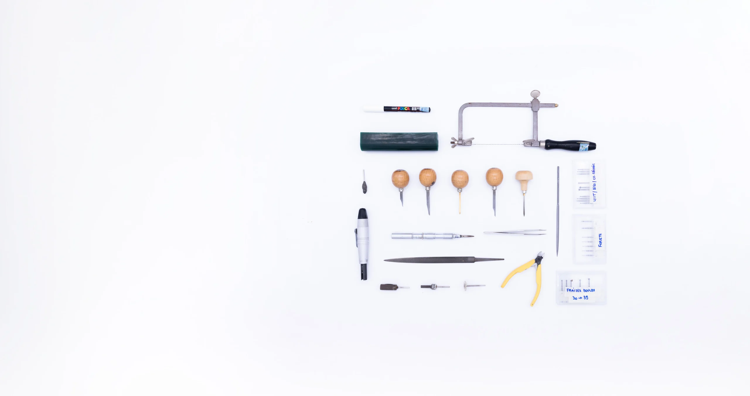 Outils de joaillier alignés : scie, limes, échoppes et pinces de l'atelier